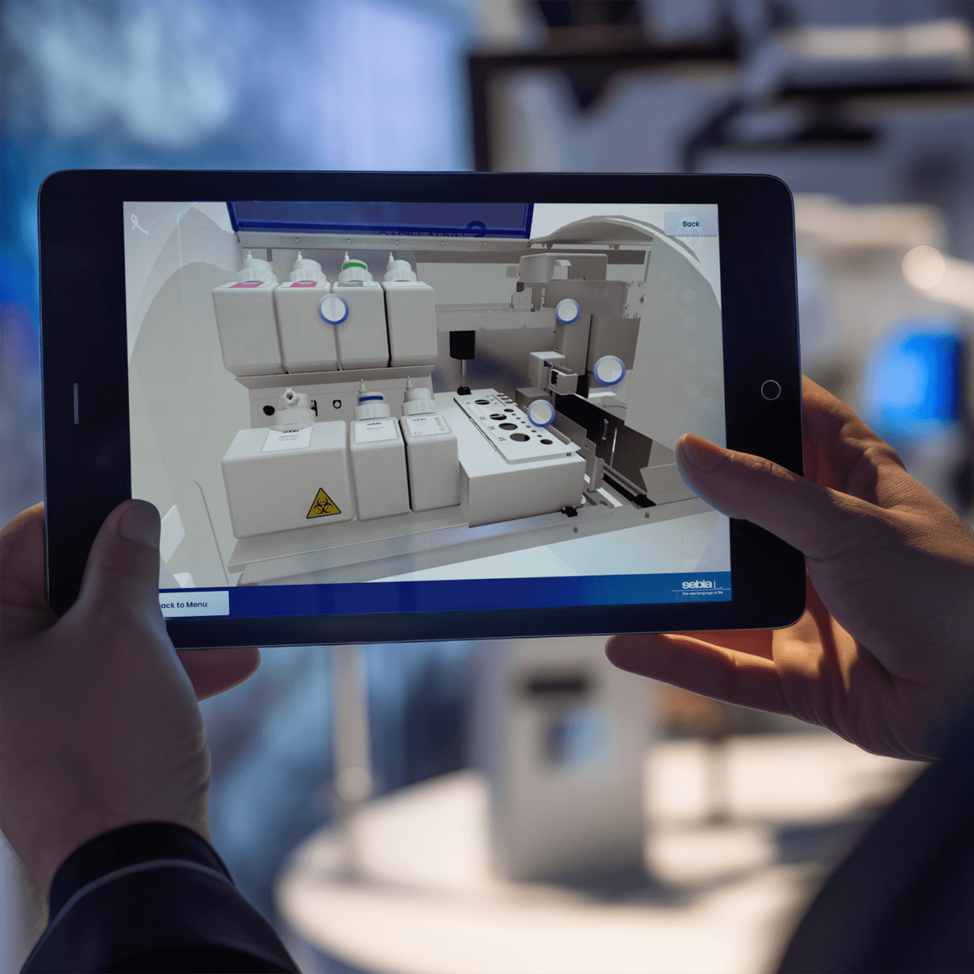 A close up of a tablet running the Sebia Sales App, the screen shows the view inside the machine with circular touch points on various components.